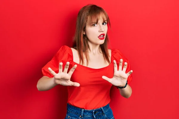 Wanita Muda Berambut Merah Yang Mengenakan Kaos Merah Kasual Takut — Stok Foto