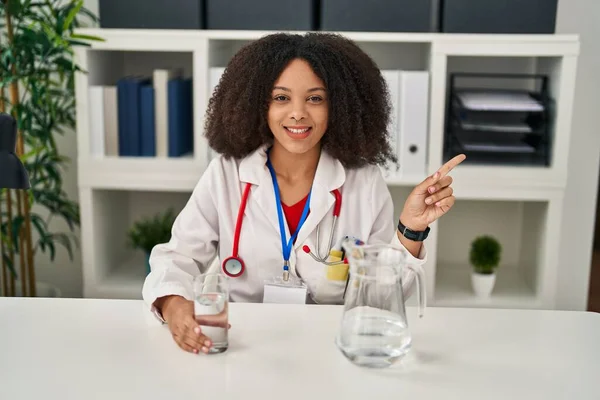 Young African American Doctor Woman Drinking Water Clinic Smiling Happy — Stockfoto