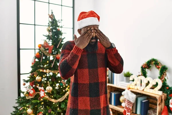 Afrykański Amerykanin Noszący Czapkę Świętego Mikołaja Stojący Obok Choinki Ocierający — Zdjęcie stockowe