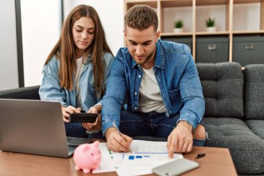 Evdeki kanepede otururken mutlu gülümseyen beyaz bir çift..