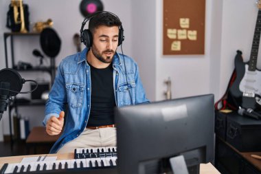 Young hispanic man artist smiling confident having video call at music studio