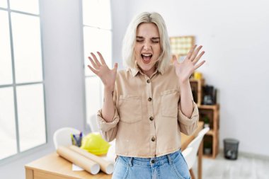 İnşaat ofisindeki genç, beyaz bir kadın başarının çılgınlığını kollarını kaldırıp, gözlerini kapatarak ve heyecanla bağırarak kutluyor. Kazanan konsept 