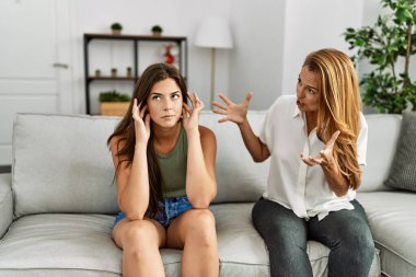 Anne ve kızı evdeki kanepede oturup tartışırken mutsuz oluyorlar.