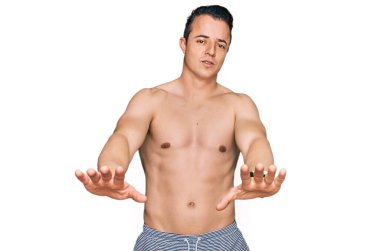 Mayo giyen yakışıklı genç adam avuç içi hareketleri, kızgın ve hayal kırıklığı ifadesi yapıyor. 