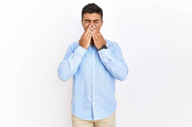 İspanyol gömlekli genç adam izole edilmiş arka planda dikilip gülüyor ve utanıyor kıkırdıyor ağızlarını ellerle, dedikoduyla ve skandal konseptiyle kapatıyor. 