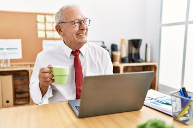 Üst düzey iş adamı kahve içiyor, ofiste çalışıyor.