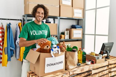 Yardım merkezinde çalışırken gülümseyen Latin asıllı gönüllü adam..