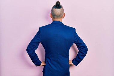 Genç İspanyol takım elbiseli ve kravatlı adam kolları vücudunda geriye doğru bakıyor. 