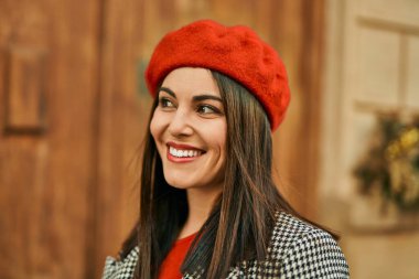 Genç İspanyol kadın gülümseyerek şehirde mutlu mesut dikiliyor..