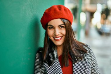 Genç İspanyol kadın gülümseyerek şehirde mutlu mesut dikiliyor..