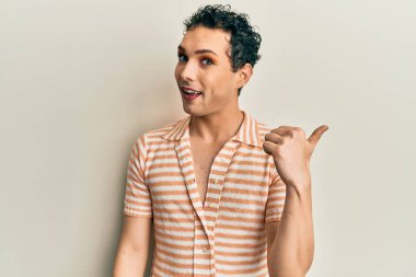 Makyaj yapan yakışıklı bir adam. Günlük tişört giyiyor. Gülümsüyor, gülümsüyor.. 