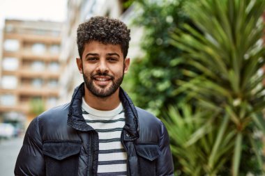 Kasabada gülümseyen genç bir Arap.