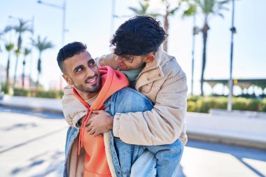 Sokakta birbirine sarılan iki erkek, erkek arkadaşını kucaklıyor.