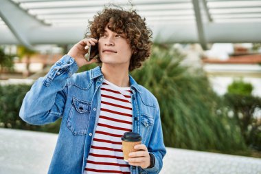 Genç İspanyol adam şehirde telefonla konuşuyor.