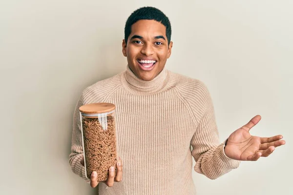 Young Handsome Hispanic Man Holding Jar Healthy Whole Grain Cereals — Stockfoto