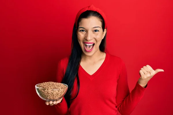 Ung Latinamerikansk Kvinna Håller Skål Med Linser Pekar Tummen Upp — Stockfoto