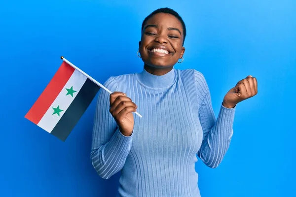 シリアの旗を持つ若いアフリカ系アメリカ人女性は誇りを持って叫んで勝利と成功を祝う非常に腕を上げ興奮して — ストック写真