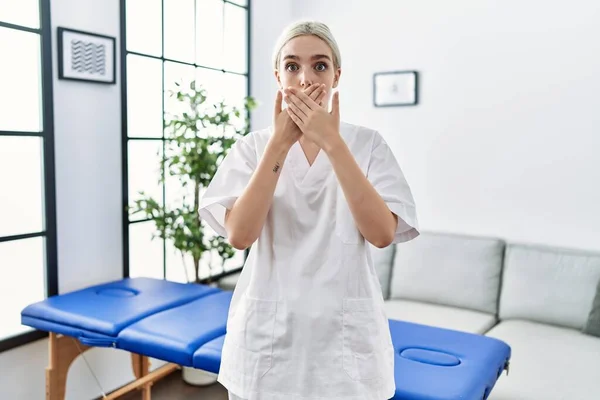 Young Caucasian Physiotherapy Woman Working Home Shocked Covering Mouth Hands — стоковое фото