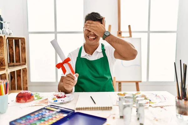Young Hispanic Man Art Studio Holding Degree Smiling Laughing Hand — стоковое фото