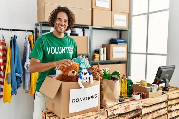 Yardım merkezinde çalışırken gülümseyen Latin asıllı gönüllü adam..