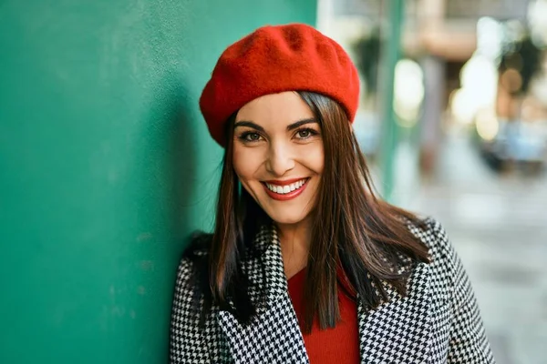 Genç İspanyol kadın gülümseyerek şehirde mutlu mesut dikiliyor..