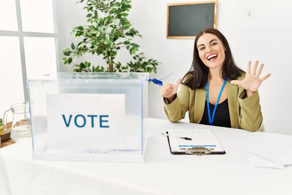 Joven Morena Sentada Mesa Electoral Con Boleta Electoral Mostrando Señalando —  Fotos de Stock