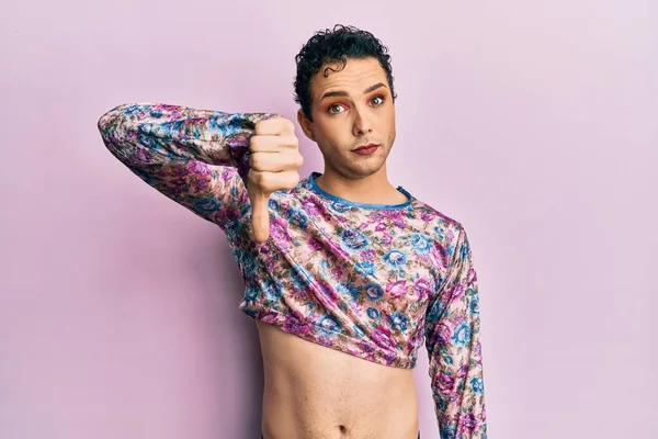 Makyaj elbisesi giymiş yakışıklı bir adam mutsuz görünüyor, kızgın, reddedilmiş ve olumsuz bir hareket sergiliyor. kötü ifade. 