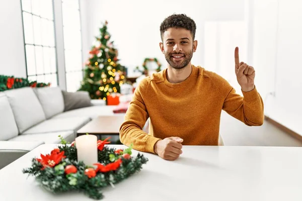 Arab Young Man Sitting Table Christmas Tree Showing Pointing Finger — Stock Photo, Image