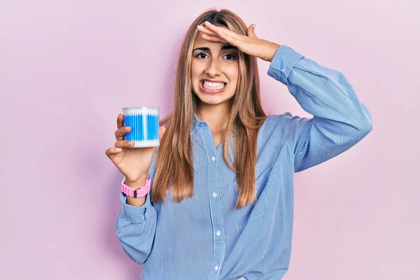 Kulak kiri temizleyicileri tutan güzel İspanyol kadın. Stresli ve hayal kırıklığına uğramış, şaşırmış ve kızgın yüzlü. 