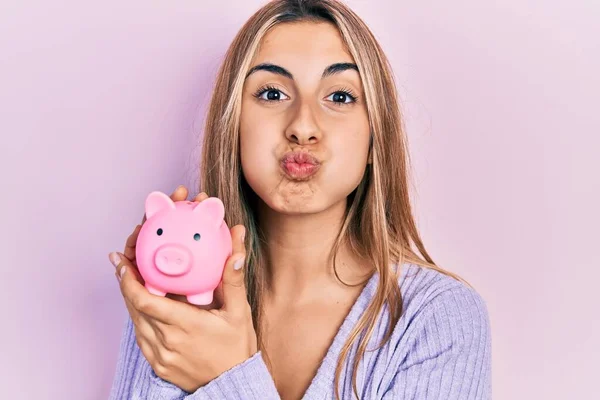 Beautiful Hispanic Woman Holding Piggy Bank Puffing Cheeks Funny Face — 스톡 사진