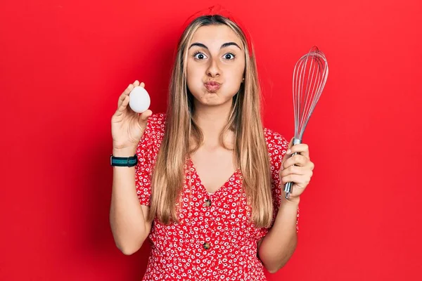 Beautiful Hispanic Woman Holding Egg Baker Whisk Puffing Cheeks Funny — Stock Photo, Image