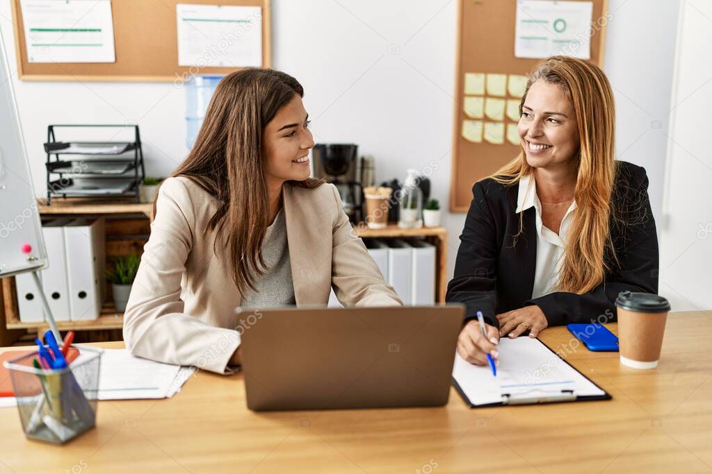 Mother and daughter business workers smiling confident working at office
