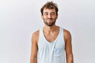 Soyutlanmış arka planda duran genç yakışıklı adam komik yüzlü yanakları tüttürüyor. Havayla şişmiş ağız, çılgın bir ifade.. 