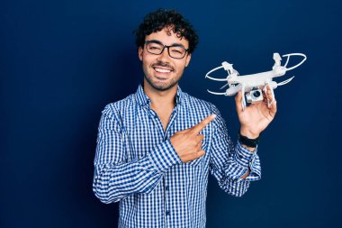 İHA 'yı tutan genç İspanyol adam gülümsüyor. 