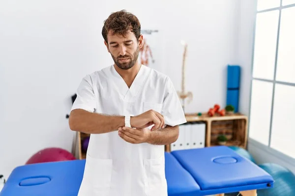 Young Handsome Physiotherapist Man Working Pain Recovery Clinic Checking Time — ストック写真