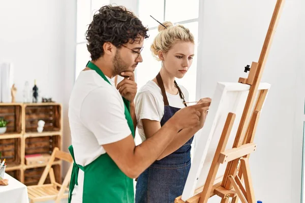 絵を描く教師の男はアートスタジオで学生の女性に教える — ストック写真