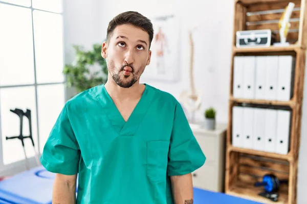 Young Physiotherapist Man Working Pain Recovery Clinic Making Fish Face — Stockfoto