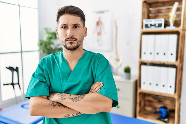 Young Physiotherapist Man Working Pain Recovery Clinic Skeptic Nervous Disapproving — Stockfoto