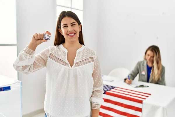 Young american voter woman holding i voted badge standing at electoral college.