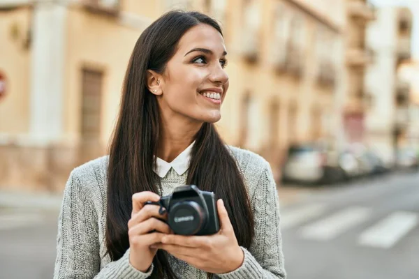 若いですヒスパニック系の女性笑顔幸せな使用してカメラで市内 — ストック写真