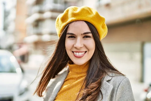 Genç İspanyol kız gülümseyerek şehirde mutlu mesut dikiliyor..