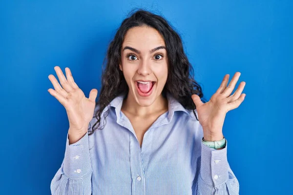 Jonge Brunette Vrouw Staan Blauwe Achtergrond Vieren Gek Verbaasd Voor — Stockfoto