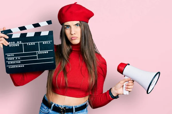 Young Brunette Teenager Holding Video Film Clapboard Megaphone Depressed Worry — Zdjęcie stockowe
