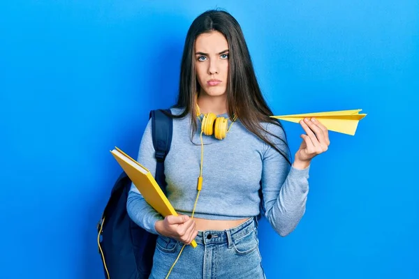 Young Brunette Teenager Student Holding Books Paper Plane Depressed Worry — Stockfoto