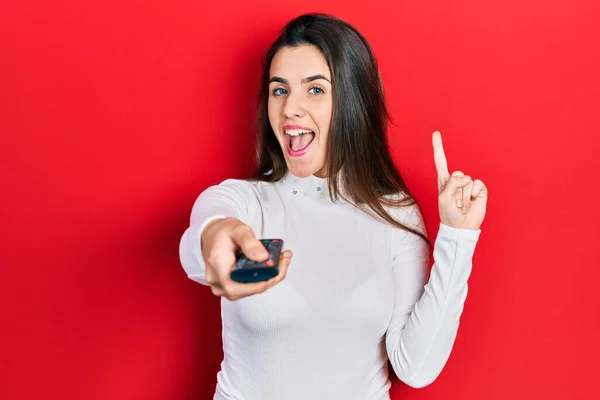 Young Brunette Teenager Holding Television Remote Control Smiling Idea Question — 스톡 사진