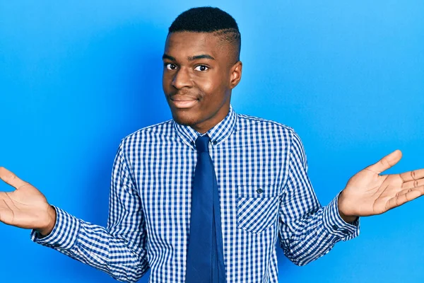 年轻的非洲裔美国人 身穿商务衬衫 系着一条毫无头绪的领带 与张开双臂混淆不清 毫无头绪 面容可疑 — 图库照片