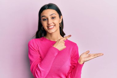 Gündelik kıyafetler giyen genç İspanyol kadın kameraya hayret ediyor ve gülümsüyor.. 