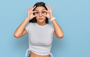 Gündelik beyaz tişört giyen genç İspanyol kız parmaklarıyla gözlerini açmaya çalışıyor, uykulu ve yorgun sabah yorgunluğu yüzünden. 