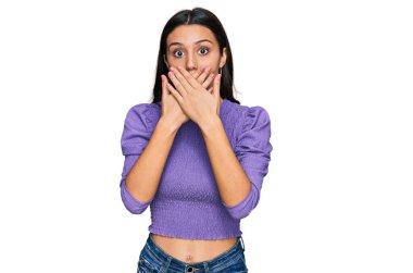 Gündelik kıyafetler giyen genç İspanyol kız yanlışlıkla elleri ile ağzını kapatırken şok oldu. gizli kavram. 