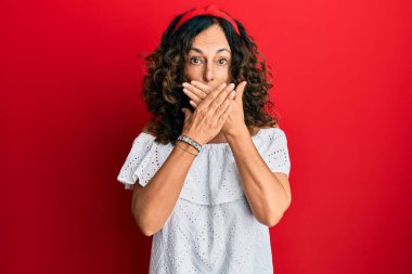 Gündelik kıyafetler giyen orta yaşlı İspanyol kadın yanlışlıkla elleri ile ağzını kapatırken şok oldu. gizli kavram. 